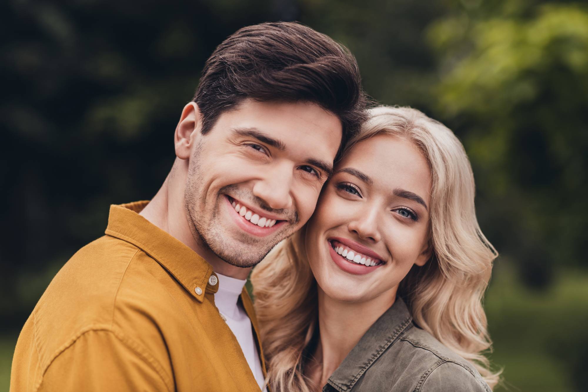 Portrait of attractive adorable careful cheerful amorous couple cuddling meeting on fresh air resting time outdoors